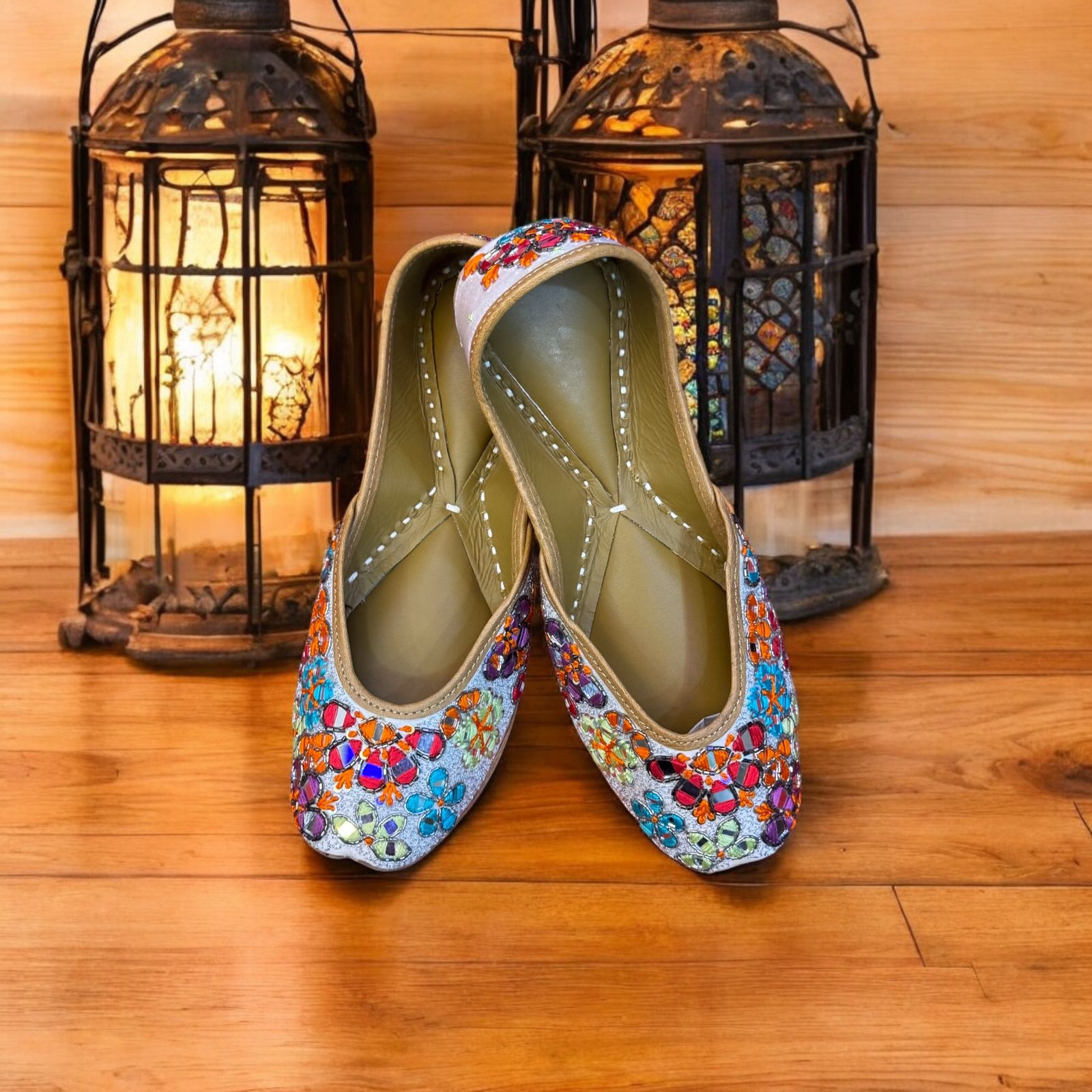 Colorful embroidered shoes on a wooden floor with decorative lanterns in the background